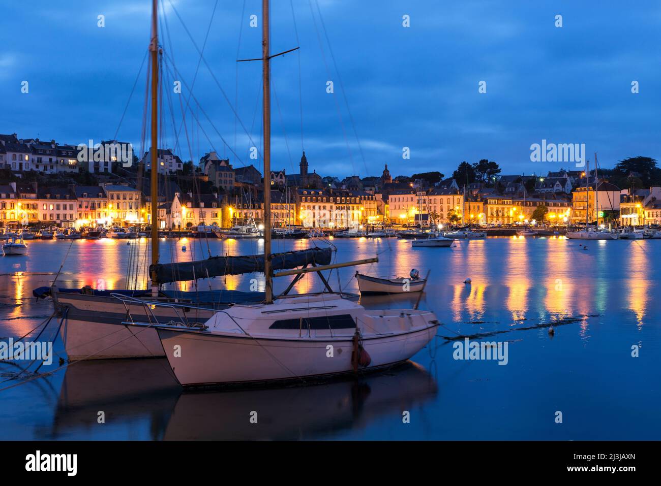 Ambiance nocturne dans le port d'Audierne, bâtiments résidentiels et commerciaux dans le quartier portuaire, France, Bretagne, Département Finistère Banque D'Images
