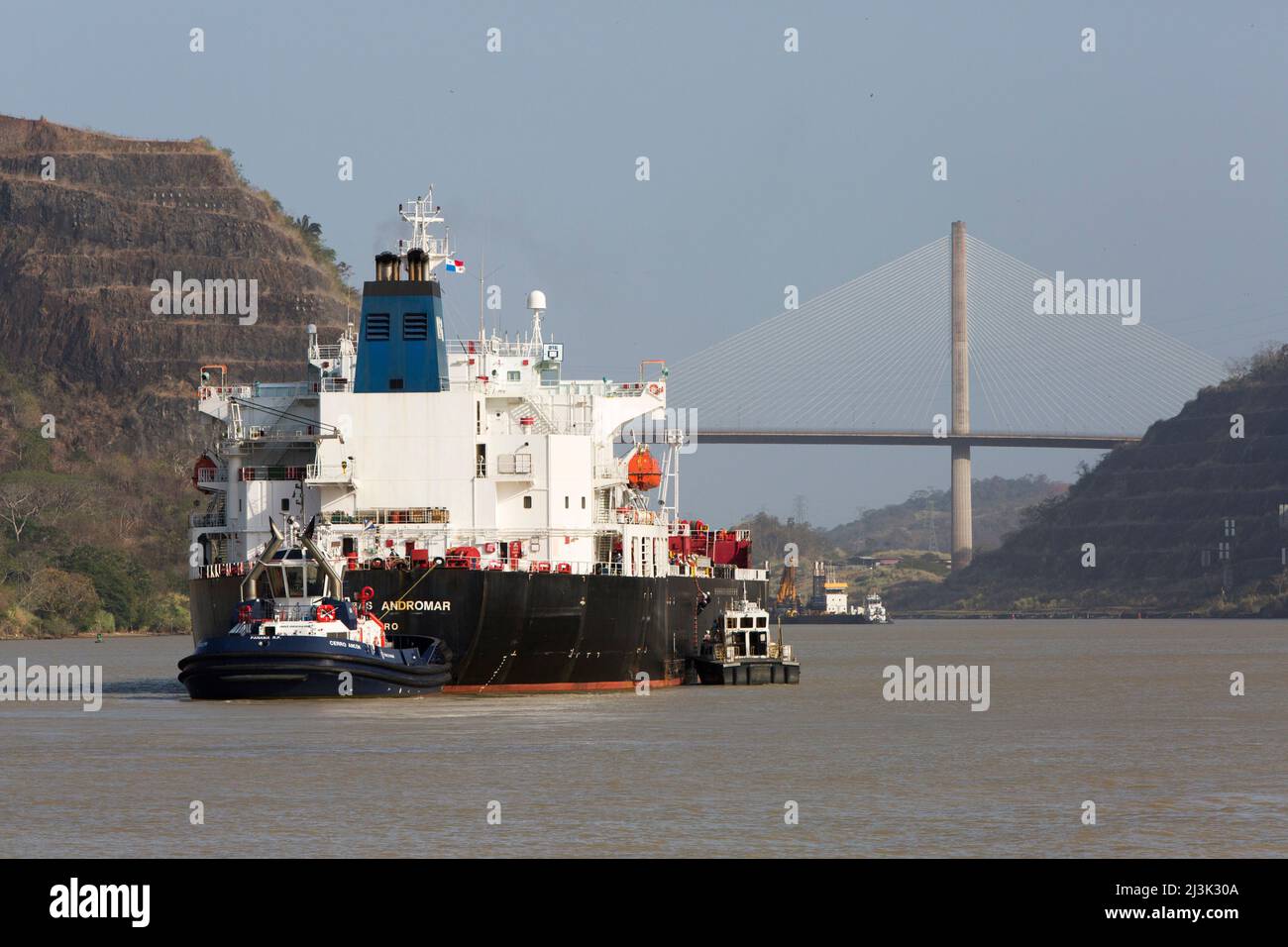 Des remorqueurs guident un grand navire à travers le canal de Panama près de Culebra Cut et du pont Centennial; Panama Banque D'Images