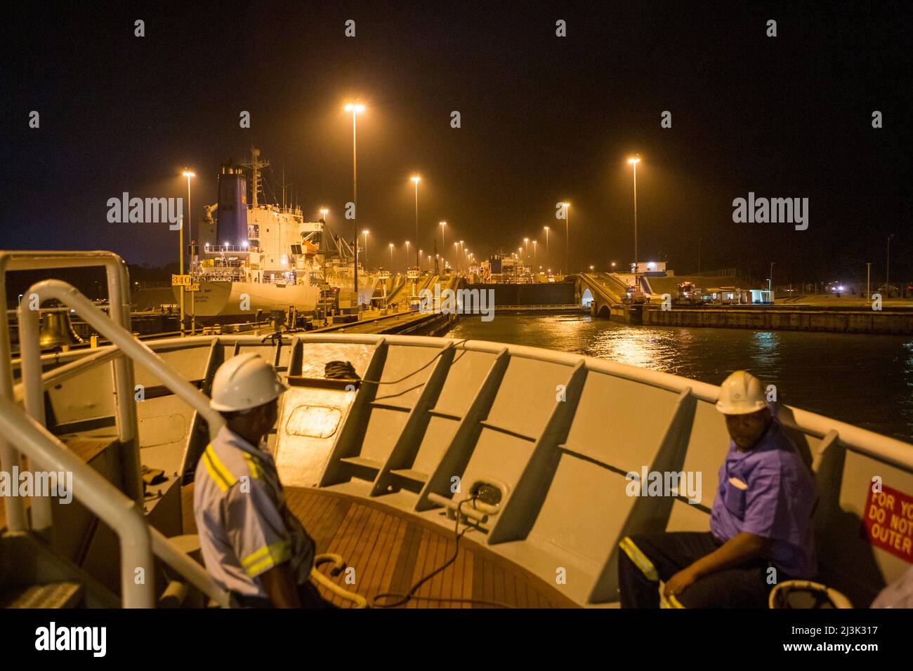 Un bateau de croisière est accompagné par le personnel du canal de Panama alors que le navire entre dans les écluses de Gatun depuis l'entrée Atlantique du canal de Panama, Panama Banque D'Images