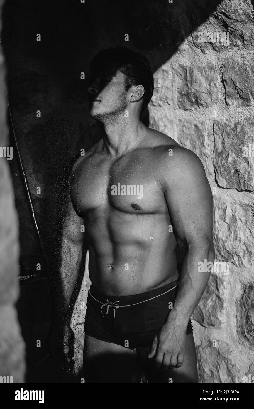 L'athlète avec de gros muscles prend une douche Banque D'Images