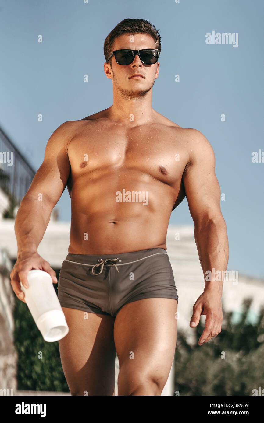 Jeune athlète avec un beau corps avec un shaker dans sa main Banque D'Images