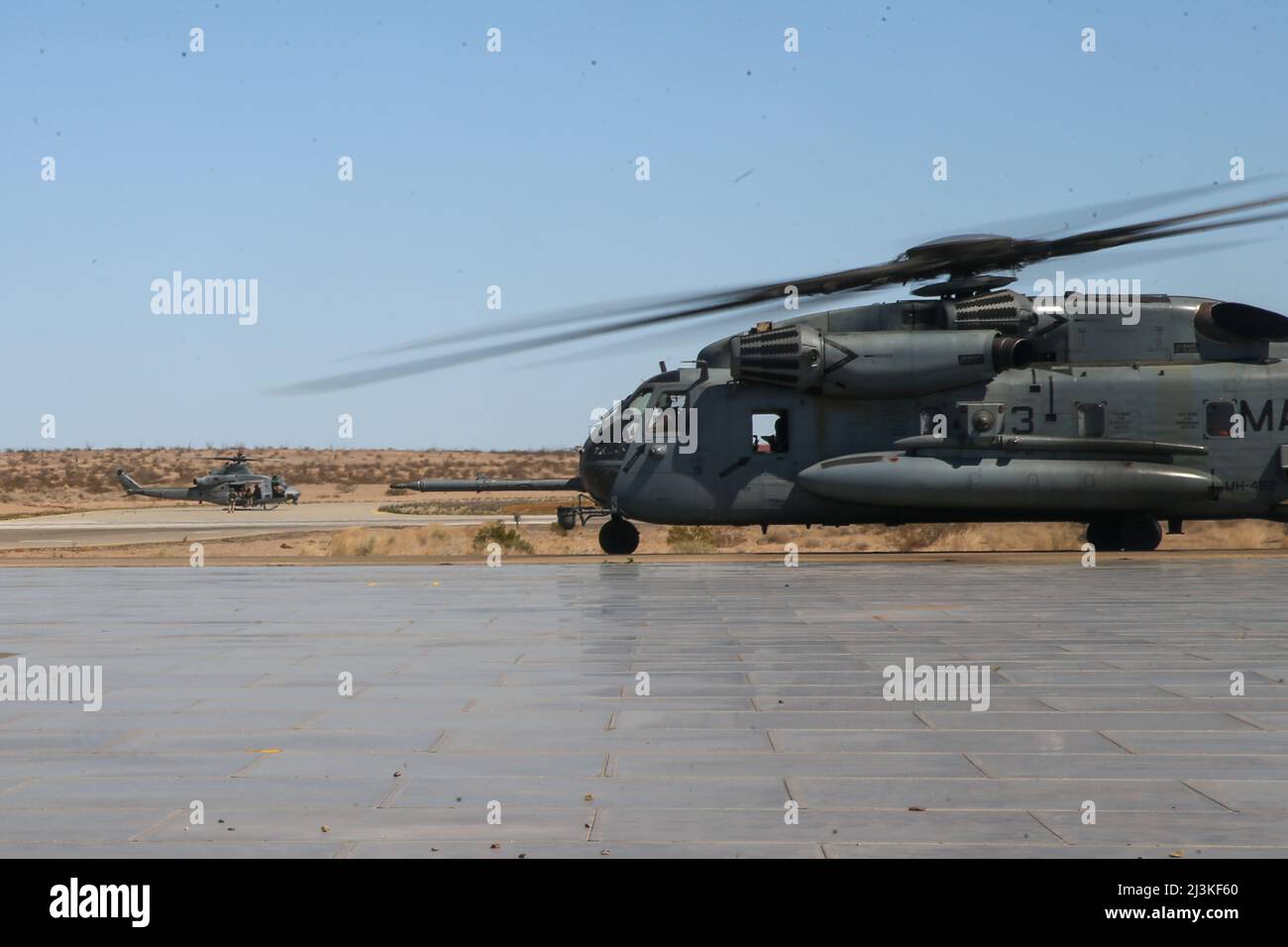 US Marine corps CH-53E Super Stallion (à droite) et UH-1Y Venom sont positionnés pour prendre le décollage pendant le cours d'instructeur d'armes et de tactiques (WTI) 2-22 à l'aérodrome de l'Armée de Laguna, Yuma Proving Ground, Arizona, 2 avril 2022. Le WTI est un événement d'entraînement de sept semaines, organisé par l'escadron 1 des armes et tactiques de l'aviation maritime, qui met l'accent sur le développement de petites expérimentations d'unités organisées par des tâches dans toutes les fonctions de combat, ainsi que sur l'amélioration de la capacité du bataillon de diriger et de contrôler, la planification de l'aide au feu, les fonctions de renseignement, et un soutien logistique au niveau de l'entreprise distribuée o Banque D'Images
