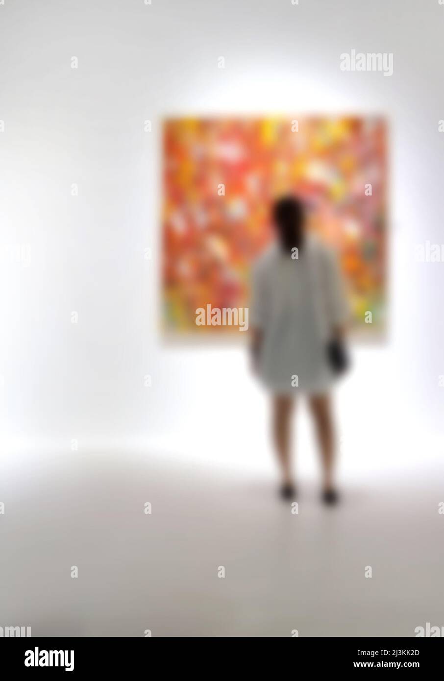 Personnes regardant des peintures sur le mur blanc dans la galerie d'exposition d'art. Arrière-plan flou. Banque D'Images