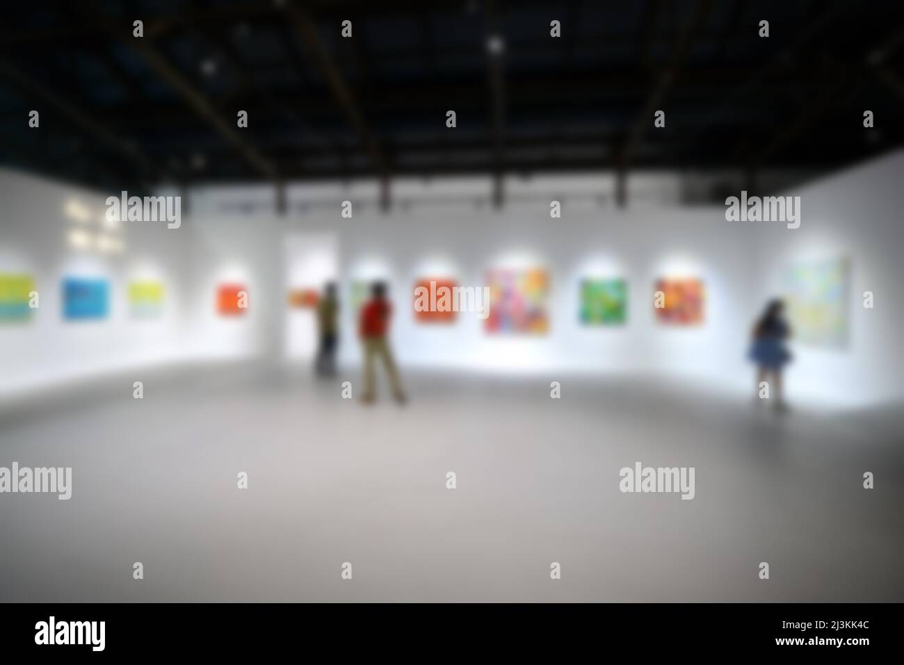 Personnes regardant des peintures sur le mur blanc dans la galerie d'exposition d'art. Arrière-plan flou. Banque D'Images