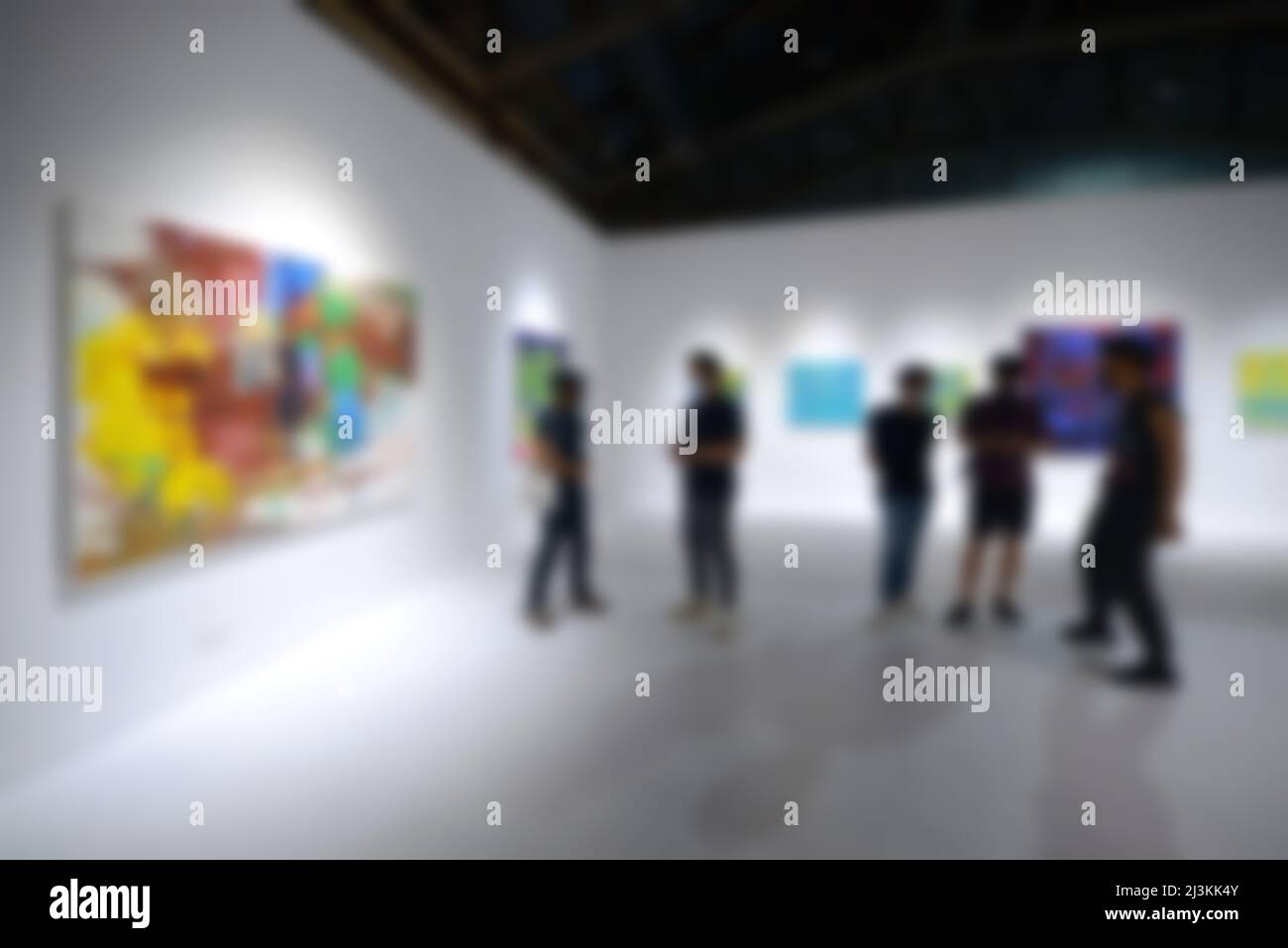 Personnes regardant des peintures sur le mur blanc dans la galerie d'exposition d'art. Arrière-plan flou. Banque D'Images