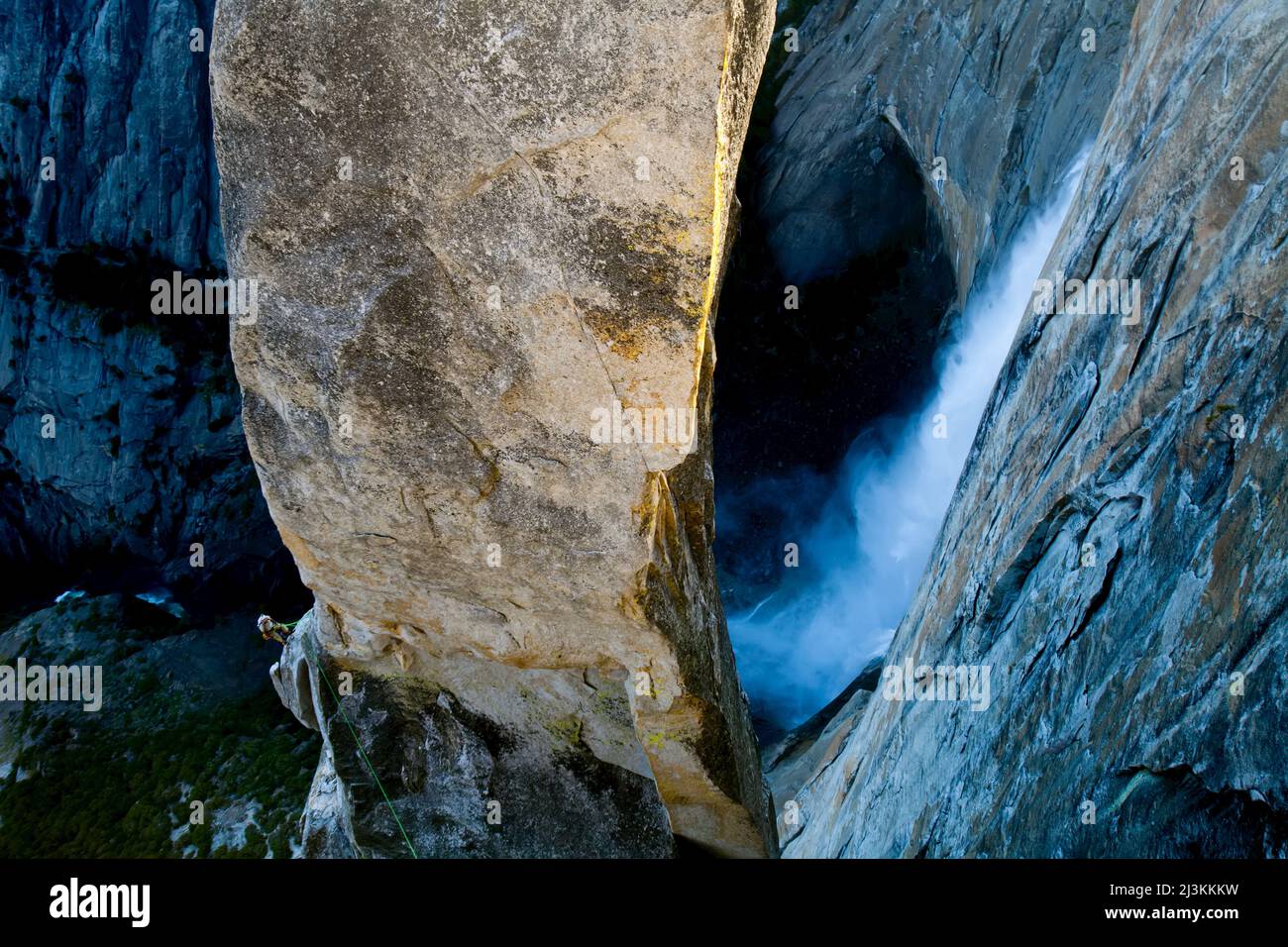 Un grimpeur sur la partie inférieure du Lost Arrow Spire suspendu au-dessus des chutes de Yosemite. Banque D'Images
