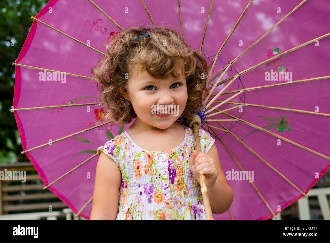 Jeune fille d'âge préscolaire avec parasol rose; Toronto, Ontario, Canada Banque D'Images