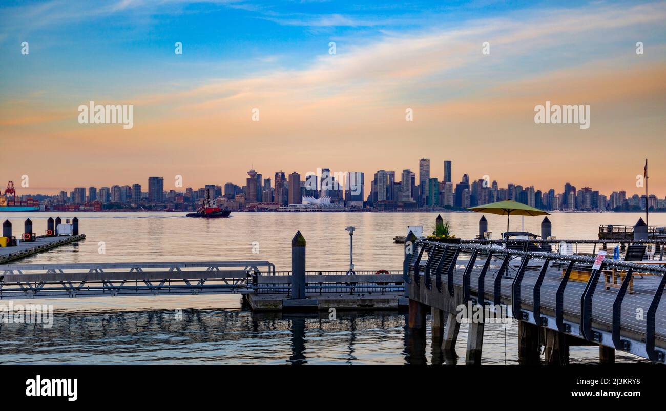 Vue sur les gratte-ciel et le front de mer du centre-ville de Vancouver depuis Lonsdale Quay, avec des couleurs de lever du soleil reflétées dans les eaux de Burrard Inlet Banque D'Images