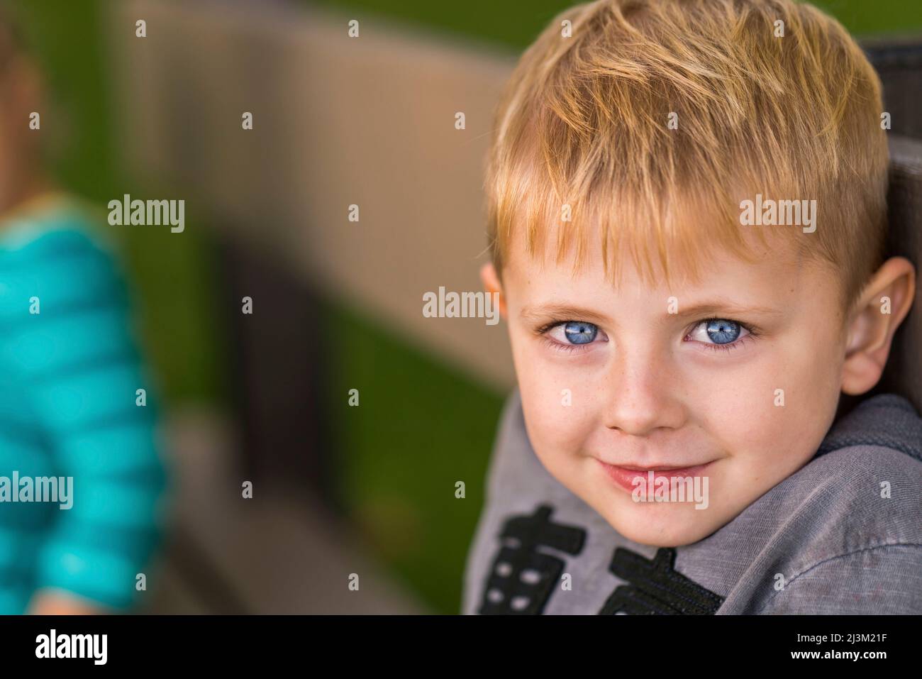Portrait en gros plan d'un jeune garçon aux yeux bleus et aux cheveux blonds; Toronto, Ontario, Canada Banque D'Images