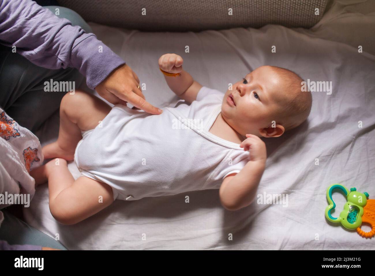 Femme jouant avec un bébé garçon allongé sur une couverture; Vientiane, Préfecture de Vientiane, Laos Banque D'Images