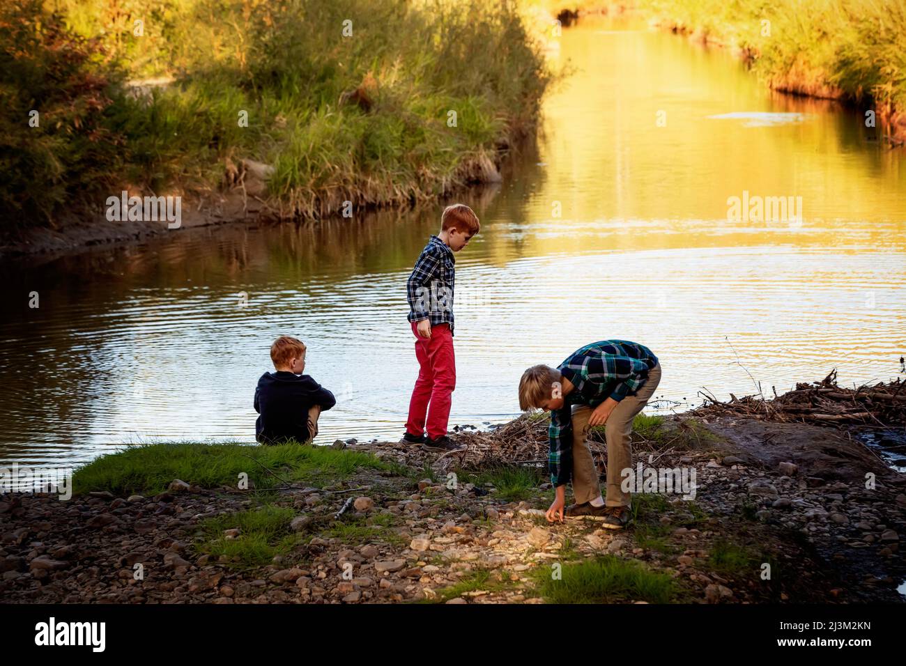 Trois frères passent du temps par l'eau dans un parc à l'automne; Edmonton, Alberta, Canada Banque D'Images