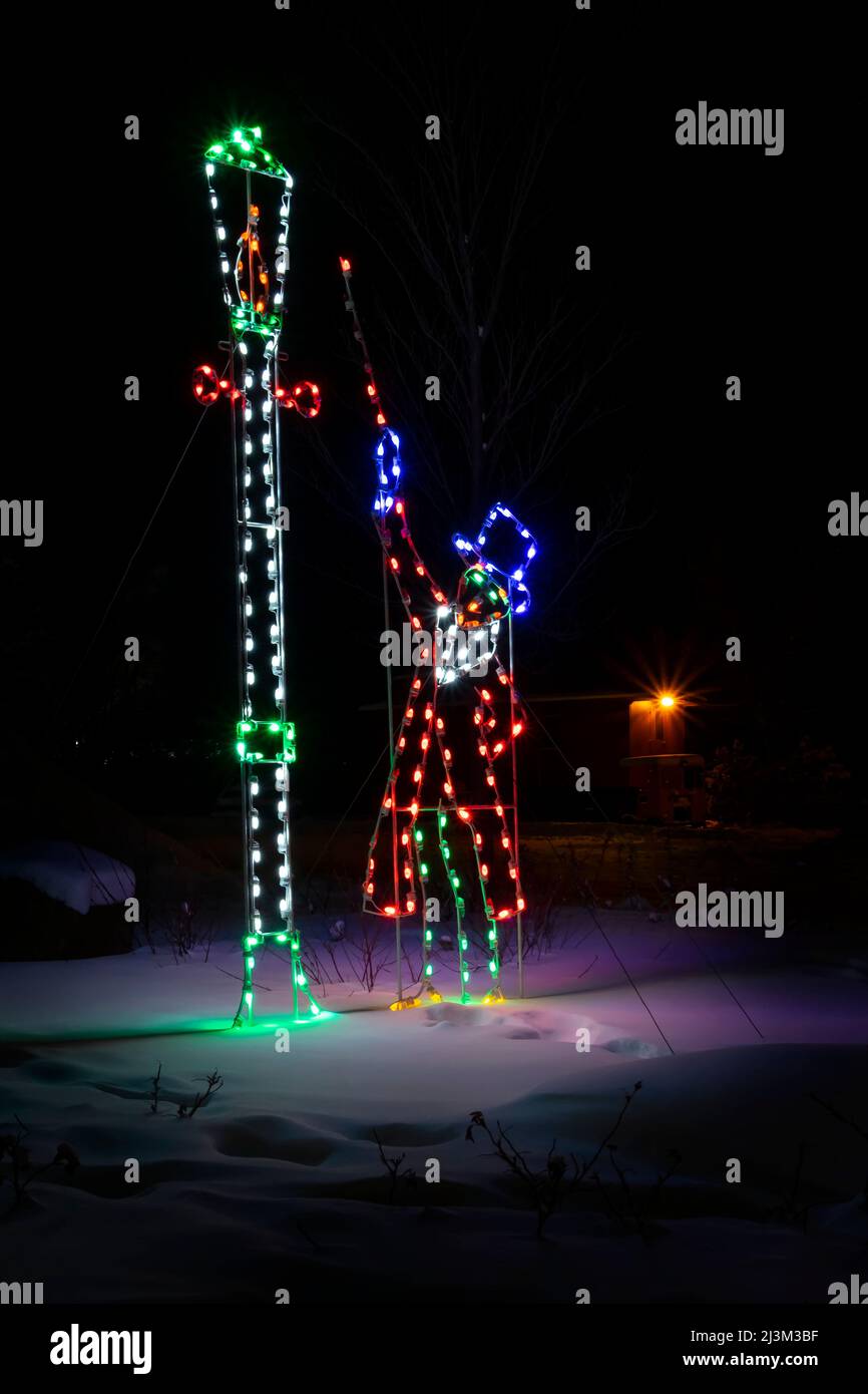 Décorations de Noël illuminées dans un parc enneigé pendant une nuit d'hiver; Stony Plain, Alberta, Canada Banque D'Images