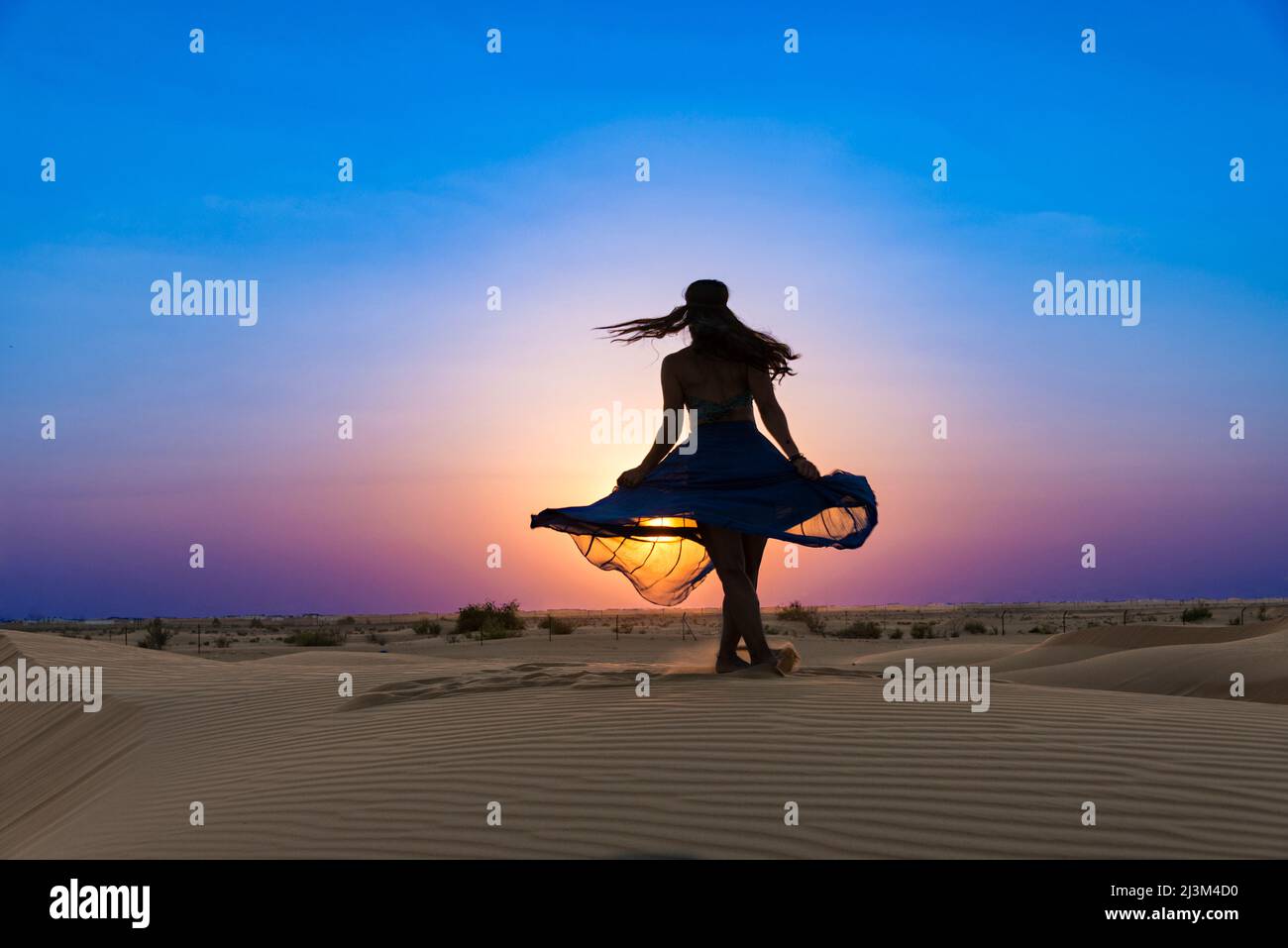 Danseur sur les sables du désert au coucher du soleil ; Abu Dhabi, Émirats arabes Unis Banque D'Images