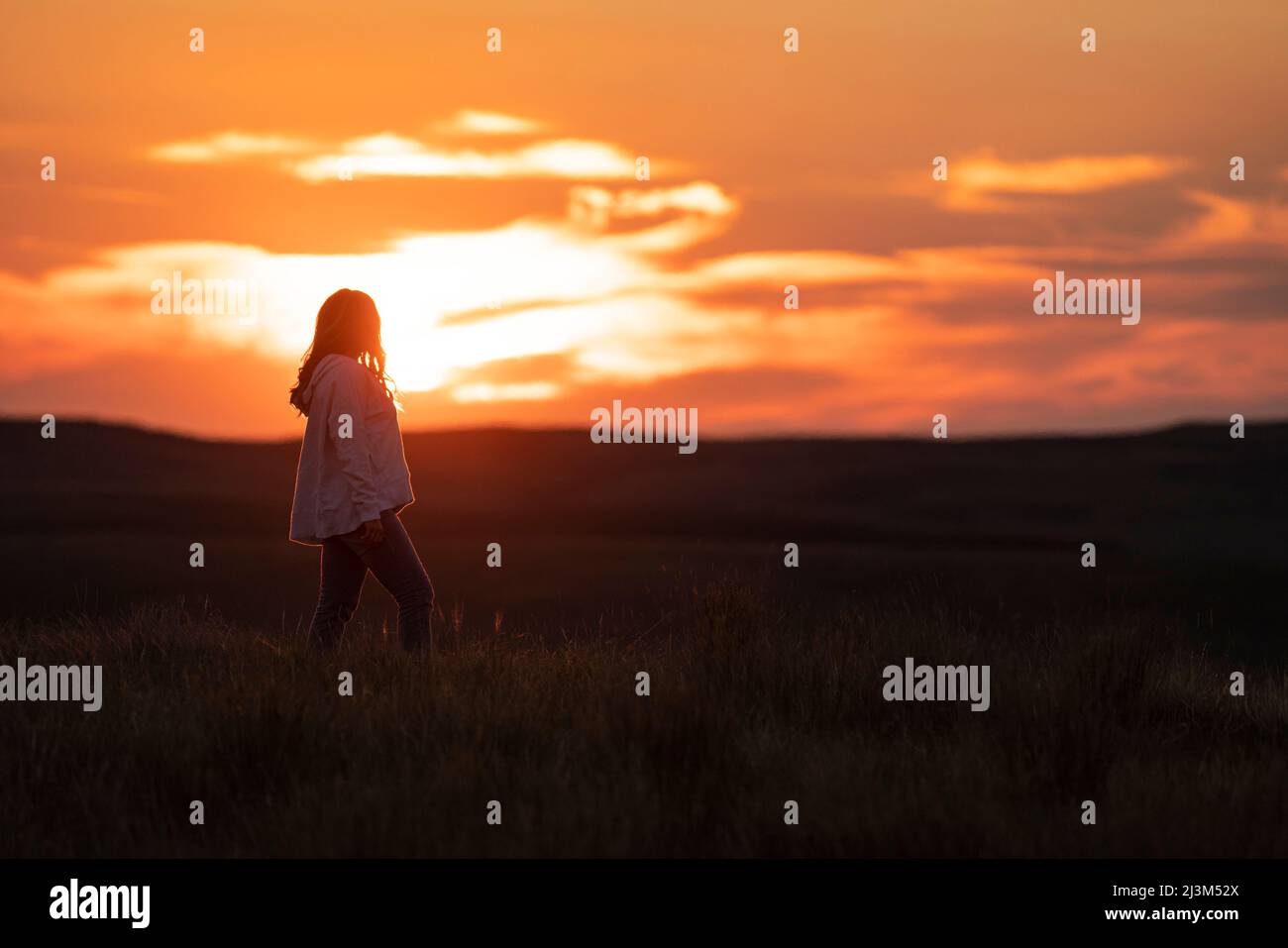 Femme profitant du coucher de soleil sur les prairies du sud de la Saskatchewan; Val Marie, Saskatchewan, Canada Banque D'Images