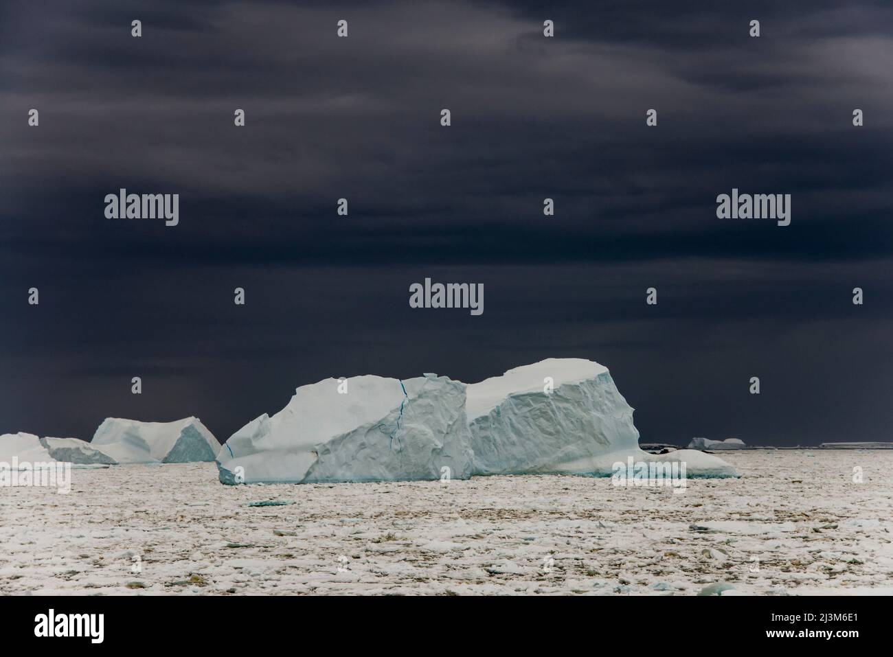 Nuages sombres derrière une banquise au détroit de Penola, un point très au sud sur la péninsule Antarctique; Antarctique Banque D'Images