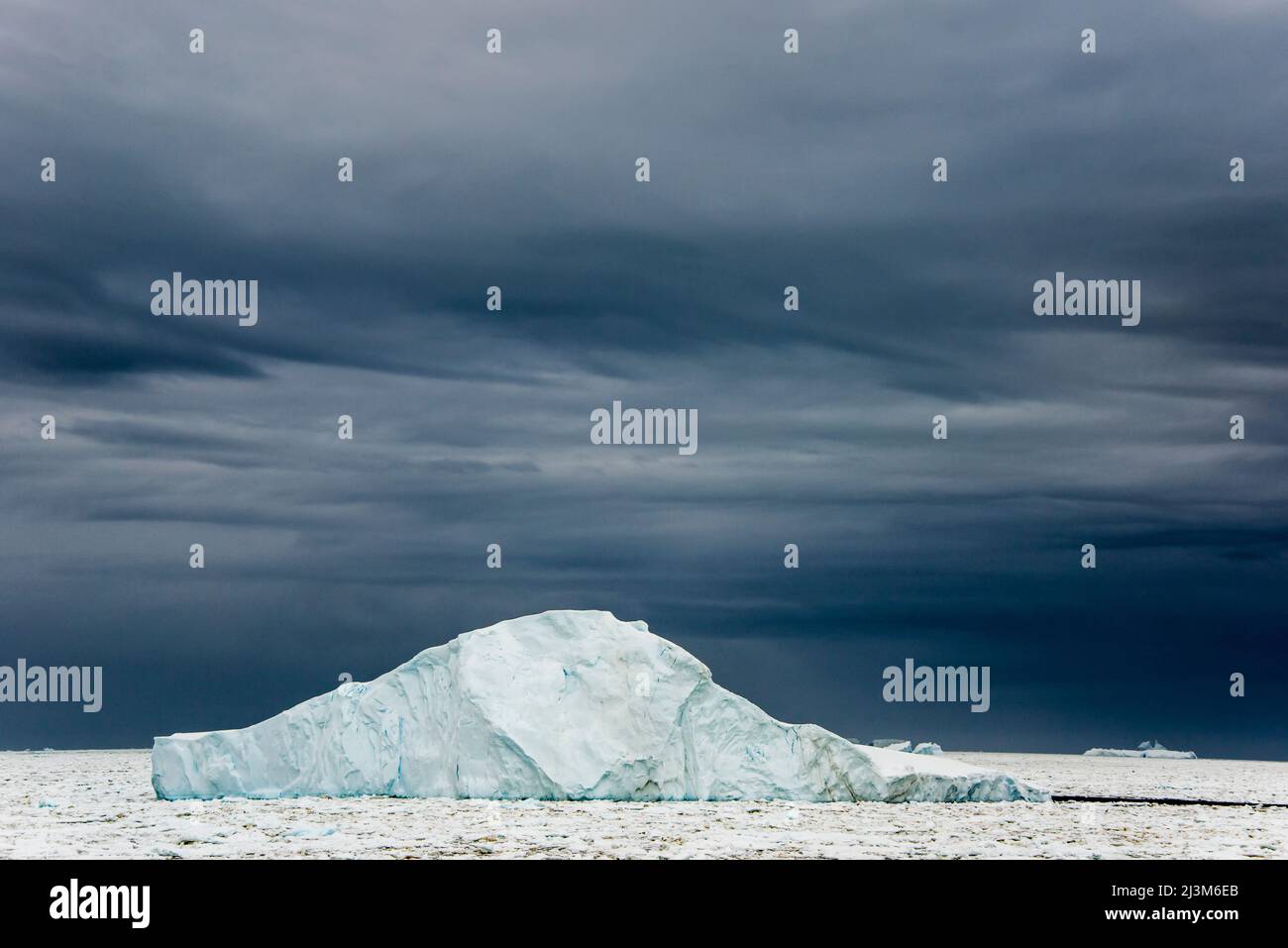 Nuages sombres derrière une banquise au détroit de Penola, un point très au sud sur la péninsule Antarctique; Antarctique Banque D'Images