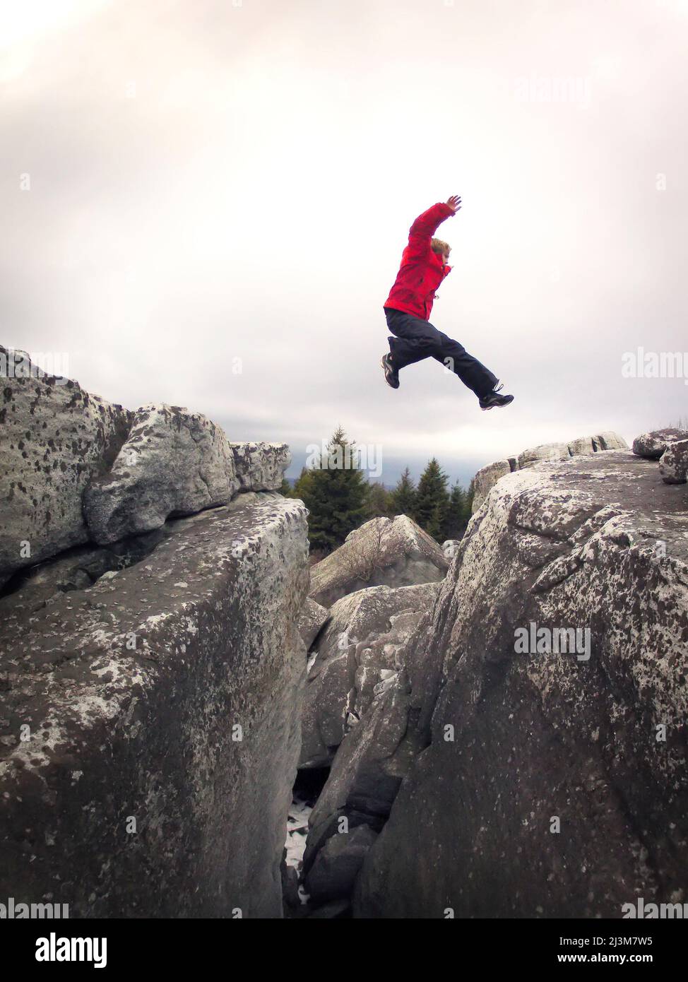 Ian Brown un garçon de 11 ans saute un ravin rocheux dans le Dolly Sods Wilderness.; Canaan Valley, Virginie occidentale. Banque D'Images