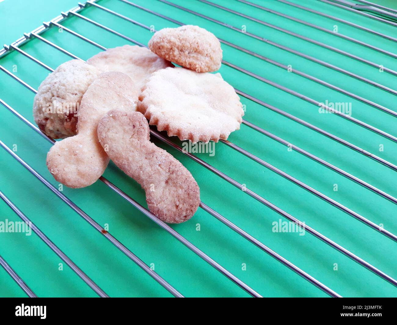 Biscuits faits maison, secs. Fond vert avec gril de cuisson en métal. Gros plan biscuits faits maison. Banque D'Images