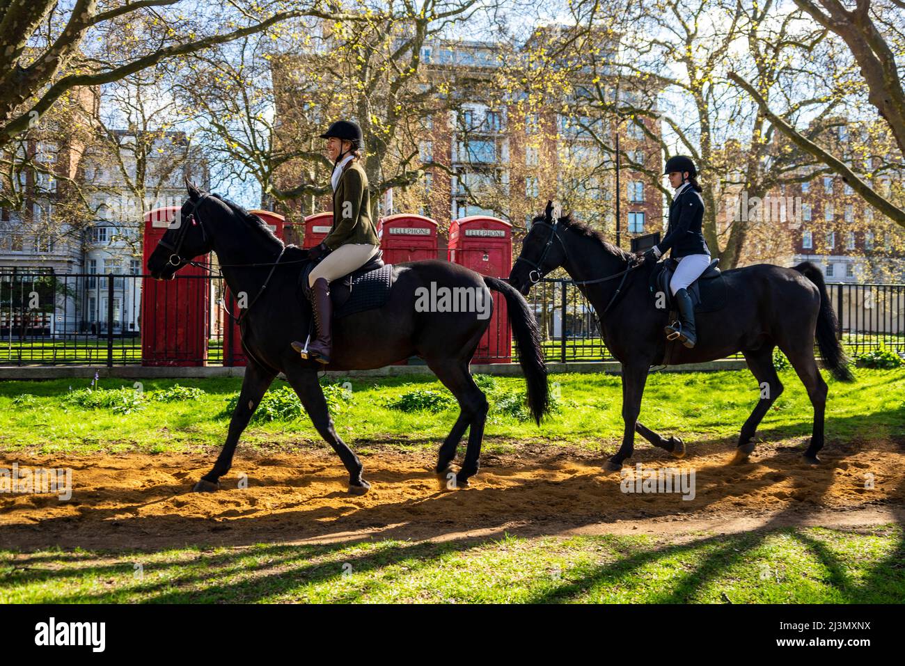 Hyde Park, Londres, Royaume-Uni. 9th avril 2022. Les cavaliers sont à Hyde Park un matin ensoleillé mais frais. Des femmes blanches de race blanche passent devant les téléphones rouges de Londres Banque D'Images
