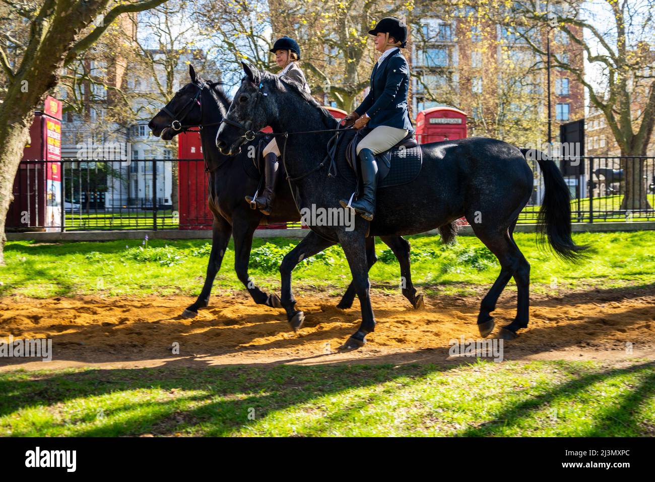 Hyde Park, Londres, Royaume-Uni. 9th avril 2022. Les cavaliers sont à Hyde Park un matin ensoleillé mais frais. Des femmes blanches de race blanche passent devant les téléphones rouges de Londres Banque D'Images