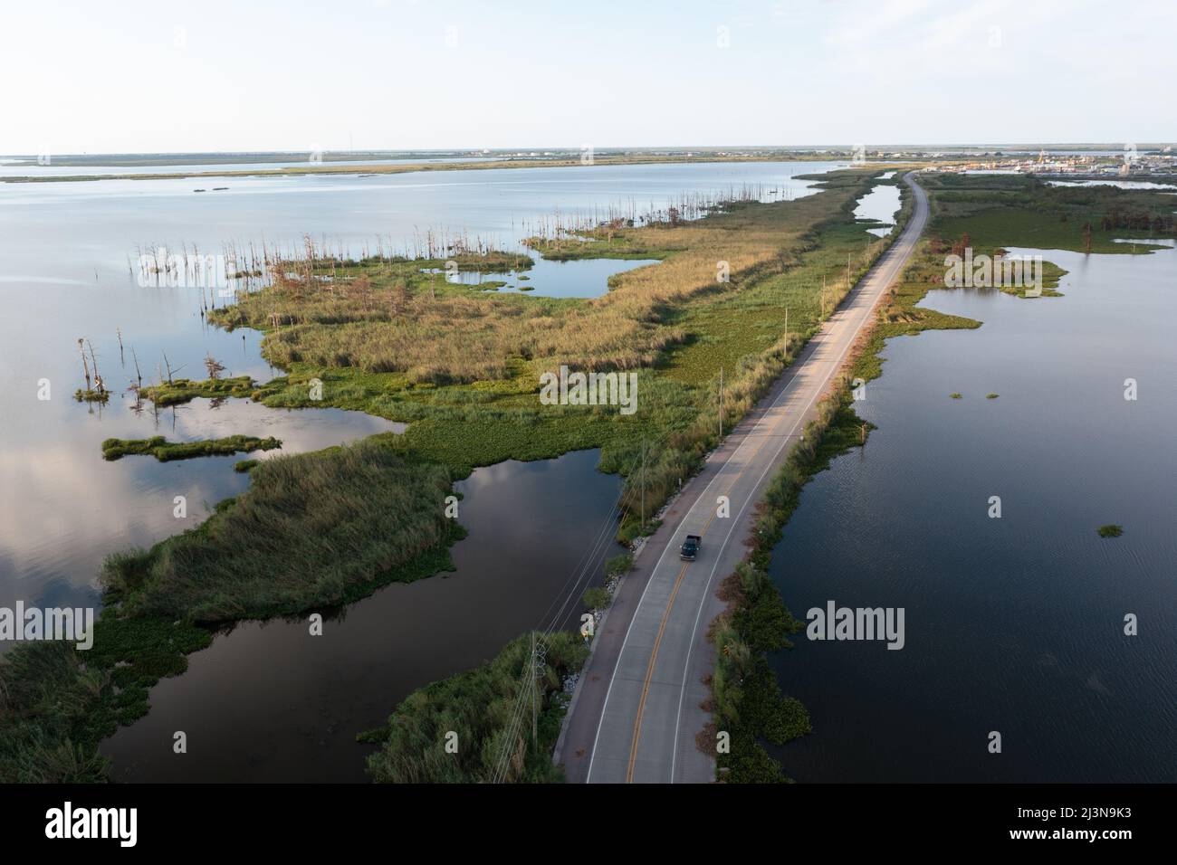 Vue aérienne d'une voiture traversant une route dans un marécage en Louisiane, près du delta du Mississippi. Banque D'Images