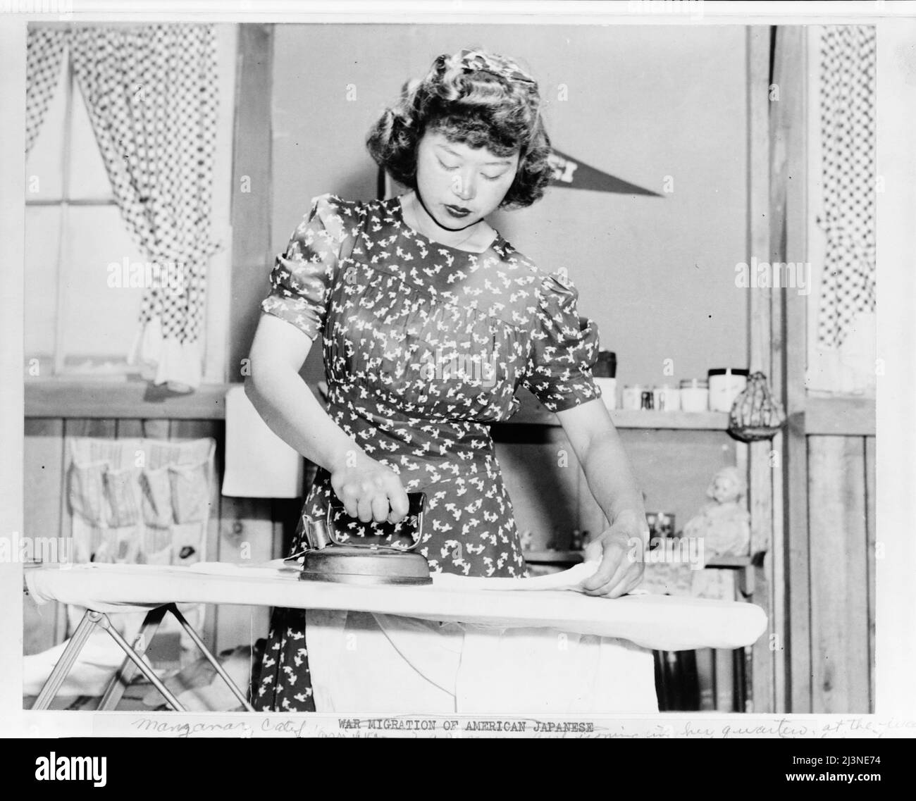 Relocalisation japonaise, Californie. Ester Naite, une employée de bureau de Los Angeles, est montrée en utilisant un fer électrique dans ses quartiers de Manzanar, Californie, un centre de l'autorité de relocalisation de guerre où les évacués d'ascendance japonaise passeront la durée. Mlle Naito travaille dans un bureau au centre. Banque D'Images