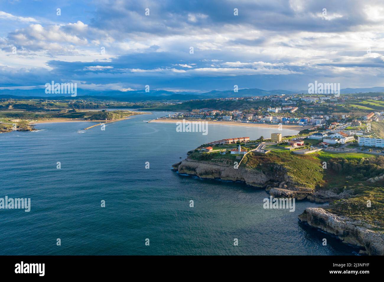 Vue aérienne de la ville côtière, plage de sable et falaises le long de la côte cantabrique dans le nord de l'Espagne, eaux calmes de l'Atlantique et lumière du soir Banque D'Images