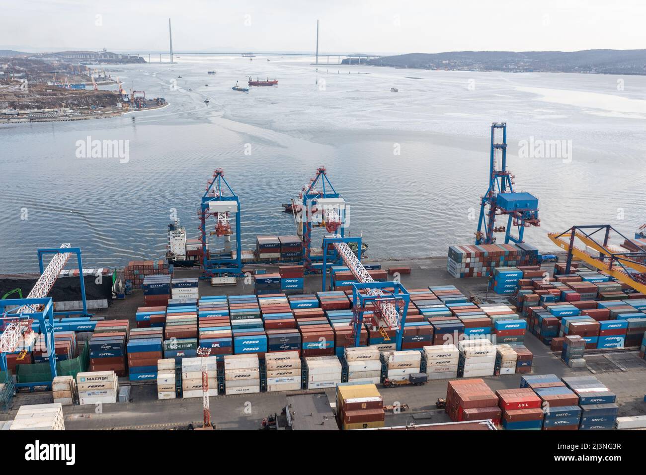 Vladivostok, Russie - 28 janvier 2022 : Vue de dessus du terminal des conteneurs du port maritime. En hiver, un bateau à conteneurs est en train de charger au quai. Banque D'Images