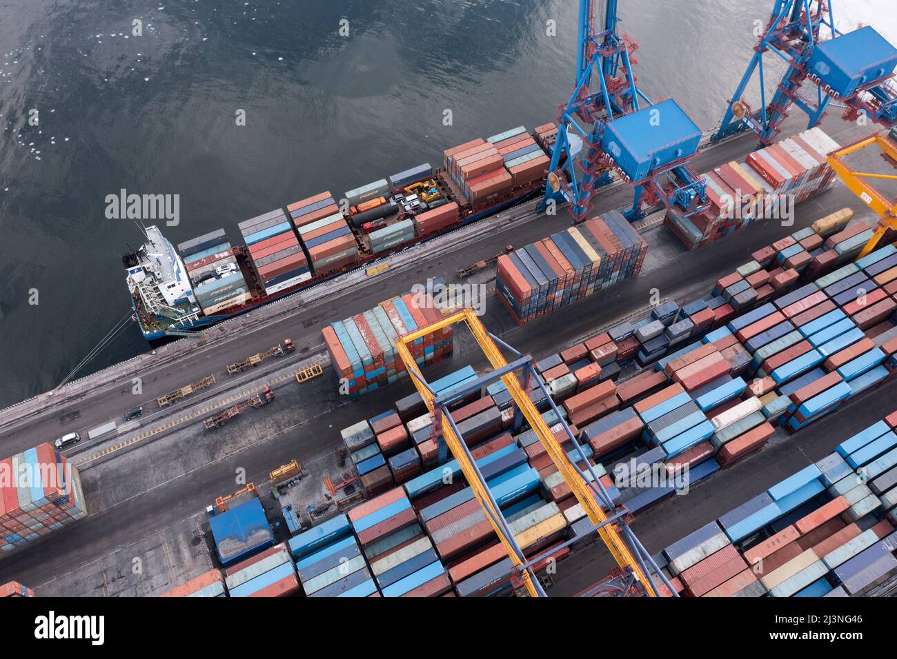 Vladivostok, Russie - 28 janvier 2022 : Vue de dessus du terminal des conteneurs du port maritime. En hiver, un bateau à conteneurs est en train de charger au quai. Banque D'Images