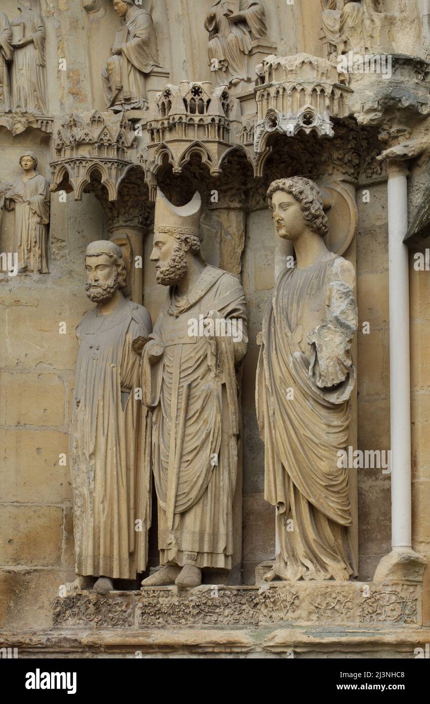 Le roi Clovis I, Saint-Remigius de Reims et un ange représenté de gauche à droite sur le portail central de la façade nord de la cathédrale de Reims (Cathédrale notre-Dame de Reims) à Reims, France. Banque D'Images