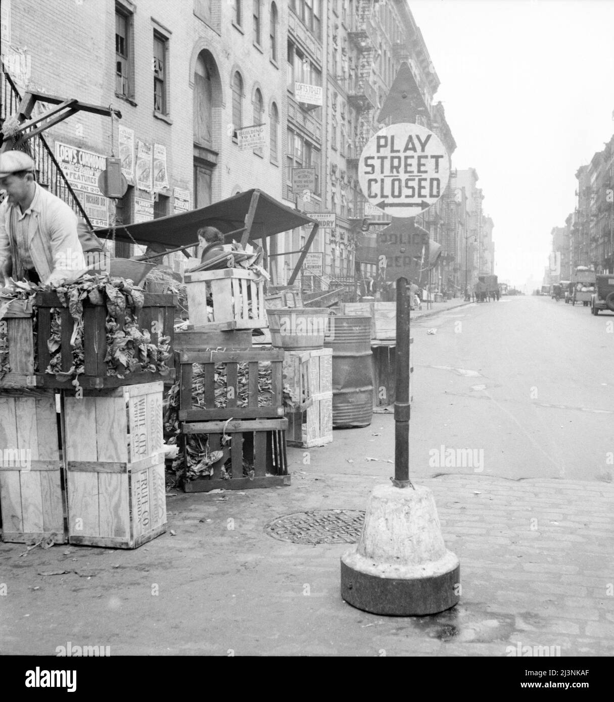 Photographie de fond pour le projet Hightstown. Jouer dans la rue pour les enfants. Sixth Street et Avenue C, New York. La famille Salomon, qui doit être réinstallée à Hightstown, vit dans ce quartier. Ce projet d'administration du réétablissement comprend deux cent cinquante foyers, quatre cent quatorze acres de terres agricoles, une usine moderne, des services publics, y compris le réseau d'aqueduc, l'aire récréative et le lac. Chaque famille aura une maison moderne et une occasion de travailler dans une usine coopérative. Aussi une petite parcelle de terre pour élever des légumes de jardin. Banque D'Images