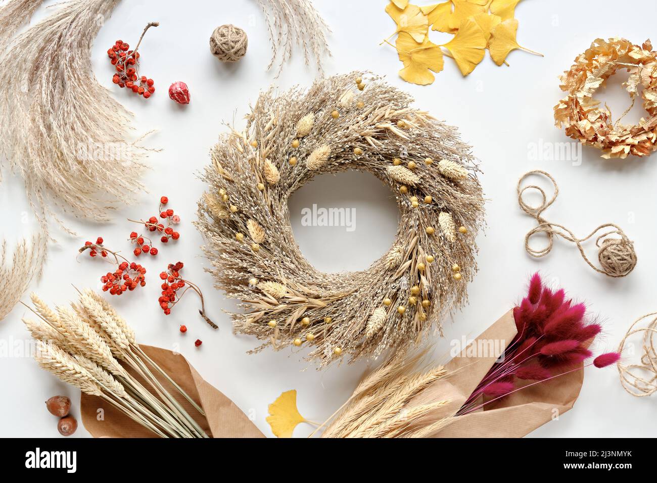Décoration naturelle Autumntime. Couronne d'herbe sèche. De blanc plat avec feuilles de ginkgo. Arrière-plan d'automne avec feuilles jaunes sèches, oreilles de blé, cordon de chanvre et Banque D'Images