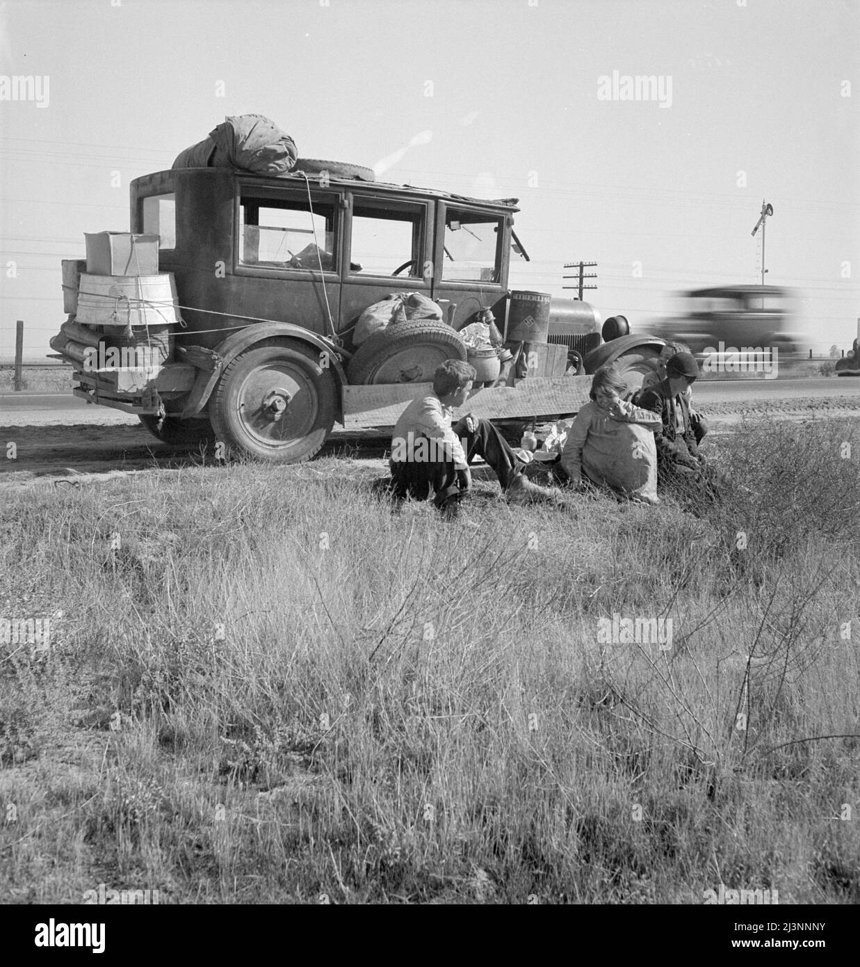 Famille de réfugiés de dépression de Tulsa, Oklahoma. Arrivé en Californie le 1936 juin. Mère et trois enfants à moitié cultivés; pas de père. « Quiconque veut travailler peut s'en sortir. Mais si une personne perd sa foi dans le sol comme beaucoup d'entre eux de retour là en Oklahoma, alors il n'y a pas d'espoir pour eux. Nous faisons tout cela ici, tout sauf pour la scolarisation, "parce que ce garçon de moi, il veut aller à l'université". Banque D'Images