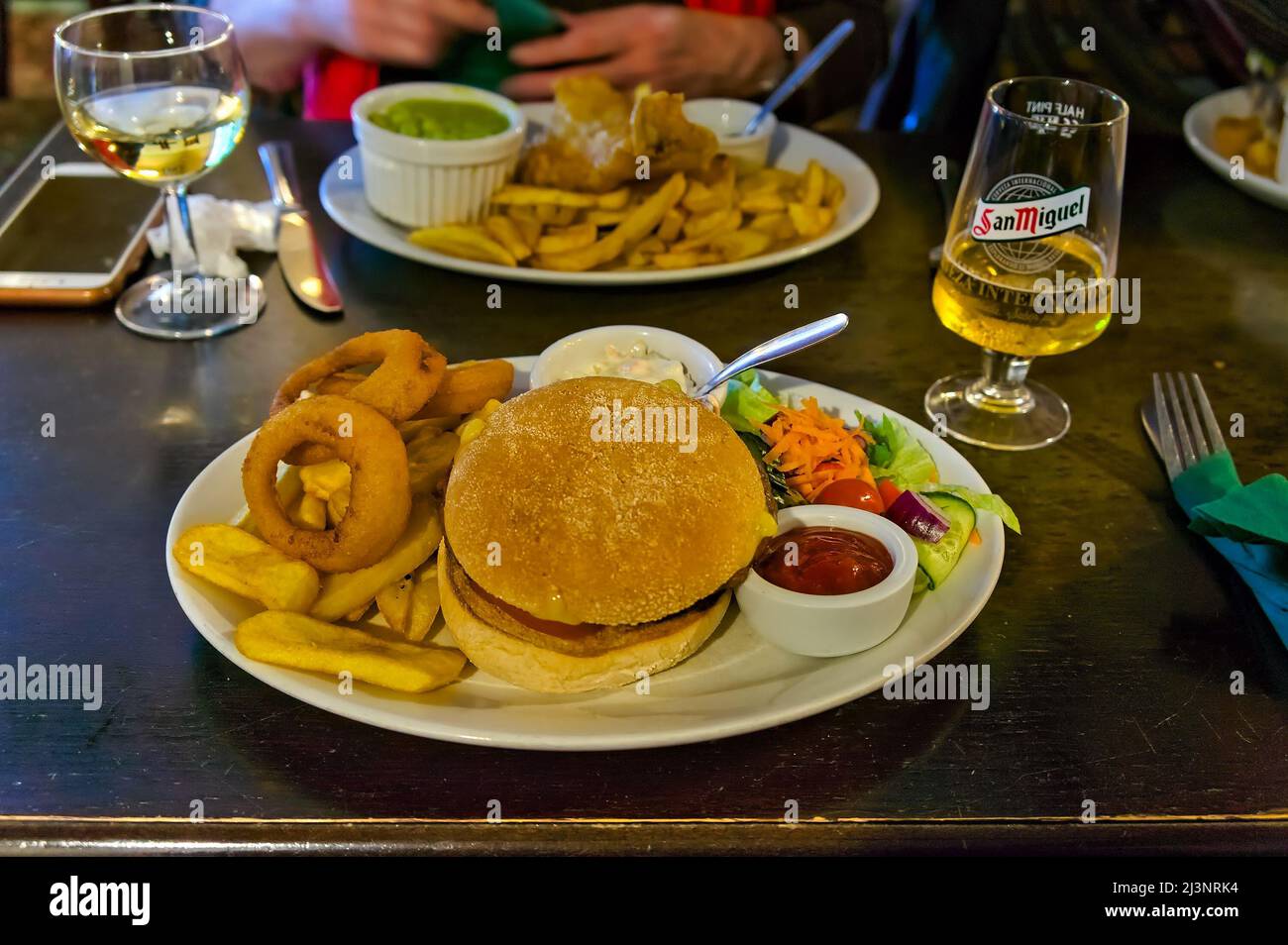 Placez le décor avec un repas hamburger & chips sur une assiette dans un restaurant Banque D'Images