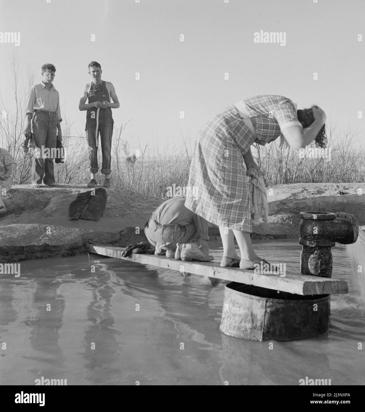 Les travailleurs migrants de l'Oklahoma se lavant dans une source chaude dans le désert. Imperial Valley, Californie. Banque D'Images