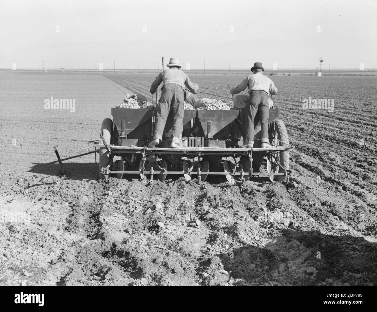 Agriculture mécanisée à grande échelle. Le plantoir de pommes de terre exploité par une équipe de trois hommes, fait les rangs, fertilise et plante les pommes de terre en une seule opération. Kern County, Californie. Banque D'Images