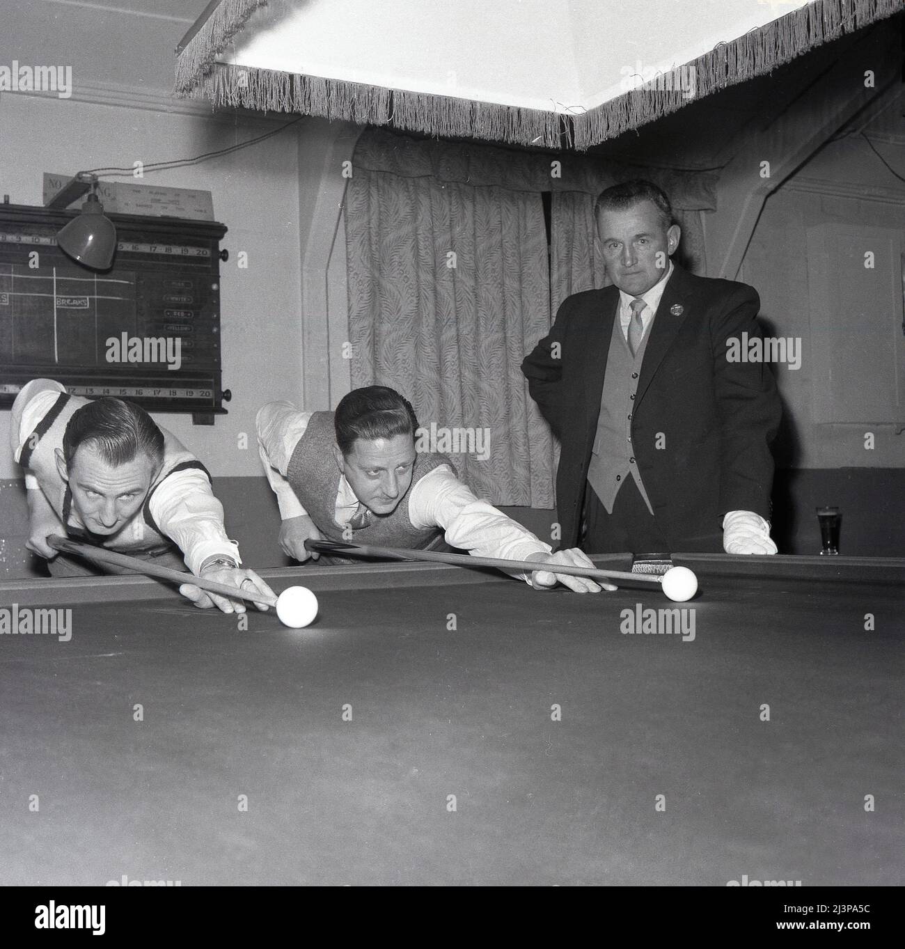 1960, historique, snooker Match, deux joueurs de snooker masculins en chemise et cravates et gilets, à la table de snooker qui s'inscrit au pot a ball, sous la surveillance de l'arbitre, Oxford, Angleterre, Royaume-Uni. Banque D'Images