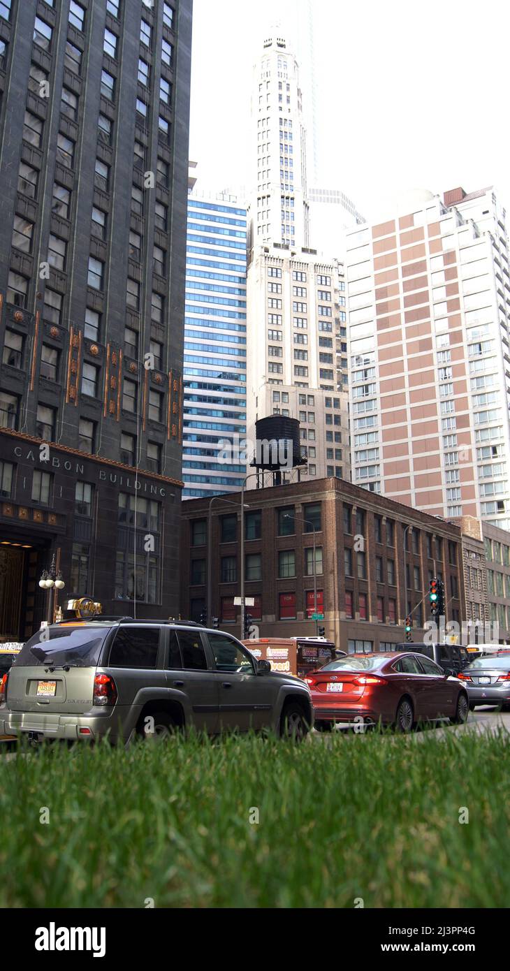 CHICAGO, ILLINOIS, ÉTATS-UNIS - DEC 11, 2015: Canyons urbains entre les gratte-ciel du centre-ville, avec des voitures au premier plan Banque D'Images