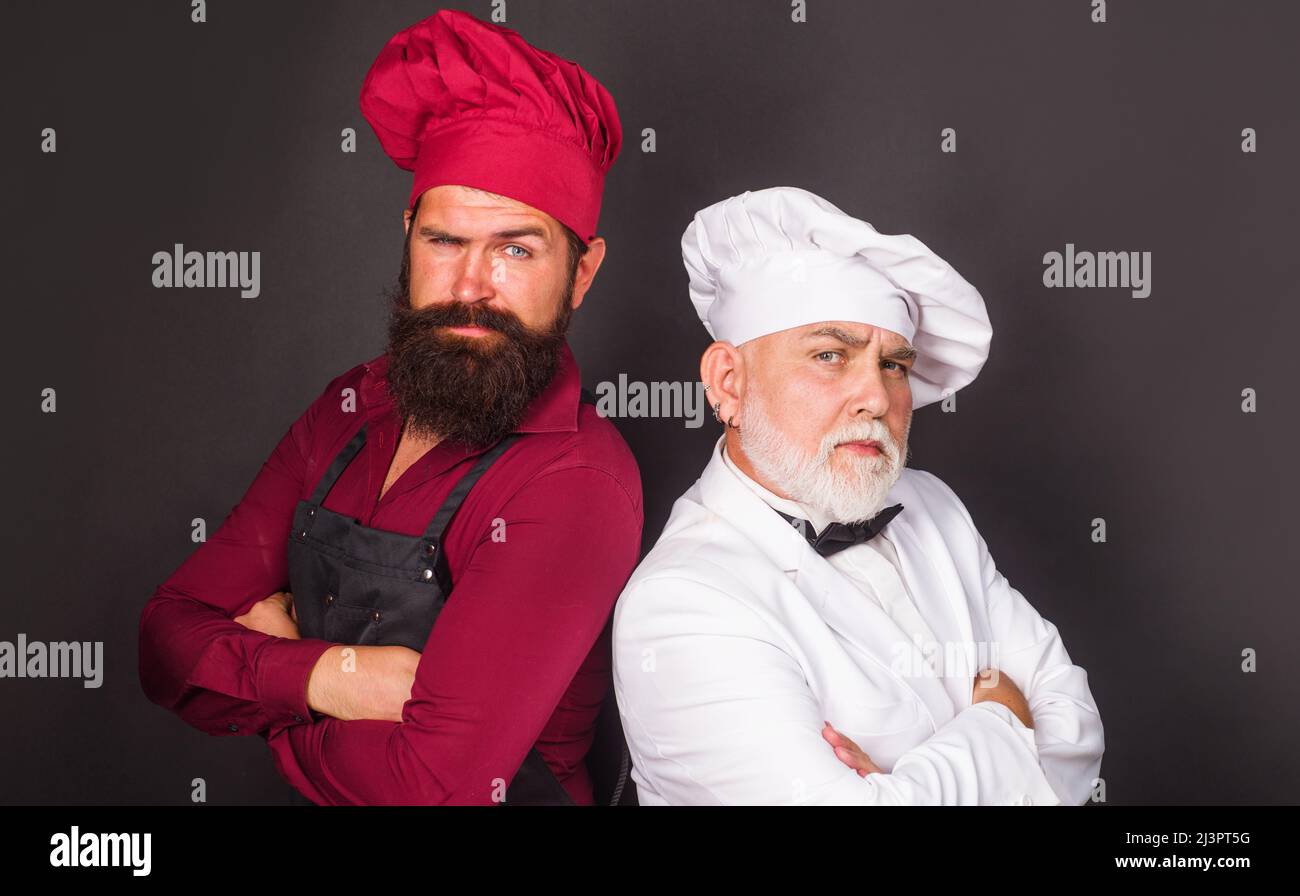 Bataille culinaire. Les chefs de restaurant en uniforme de cuisiniers se tiennent debout l'un contre l'autre. Concours de chef Banque D'Images