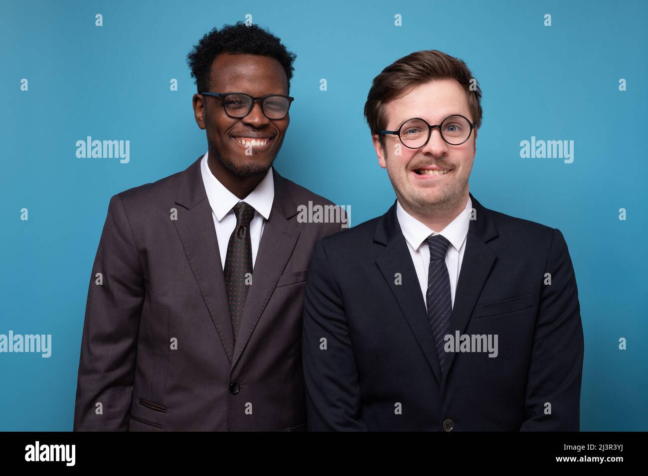 Deux jeunes hommes en costume avec grimace drôle, c'est-à-dire oops regardant la caméra. Banque D'Images Deux jeunes hommes en costume avec grimace drôle, c'est-à-dire oops regardant la caméra. Banque D'Images