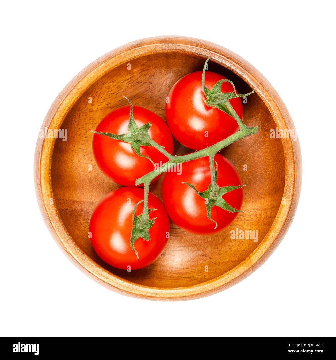 Tomates cerises rouges, dans un bol en bois. Tomates mûres, petites, rondes, cocktail sur la vigne, de la taille d'un bout de pouce, avec un goût super sucré. Banque D'Images