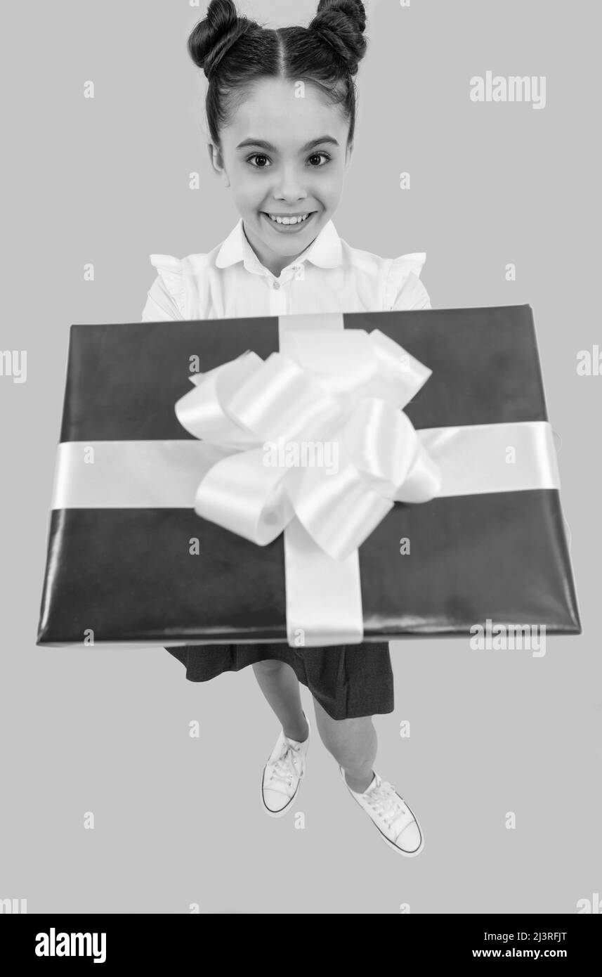 enfant d'école positif avec boîte cadeau sur fond bleu, solde Banque D'Images