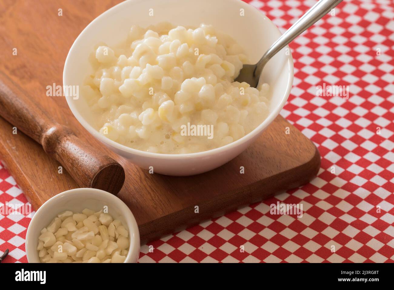 Dessert brésilien canjica sucré de maïs blanc dans un bol et une serviette. Banque D'Images