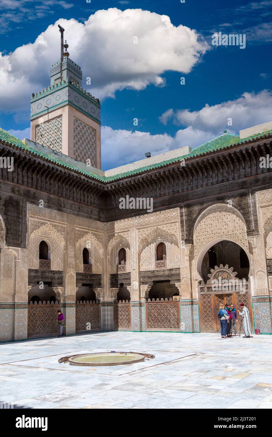 Fes, Maroc. Medersa Bou Inania. Les touristes avec guide dans la cour intérieure. Banque D'Images