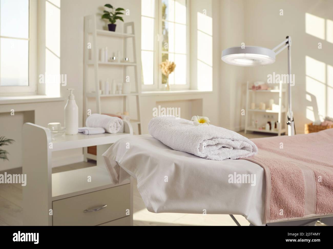 Bureau d'esthéticienne, salon de spa ou salle de massage avec lit, lampe  grossissante et produits de soin de la peau Photo Stock - Alamy