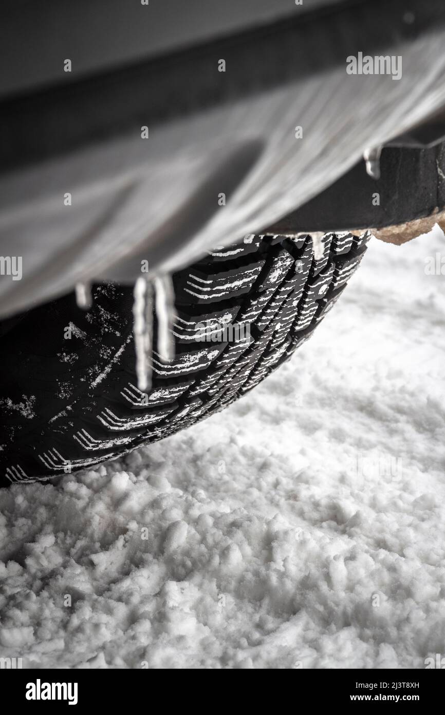 Une roue de voiture roule sur de la neige en gros plan. Banque D'Images