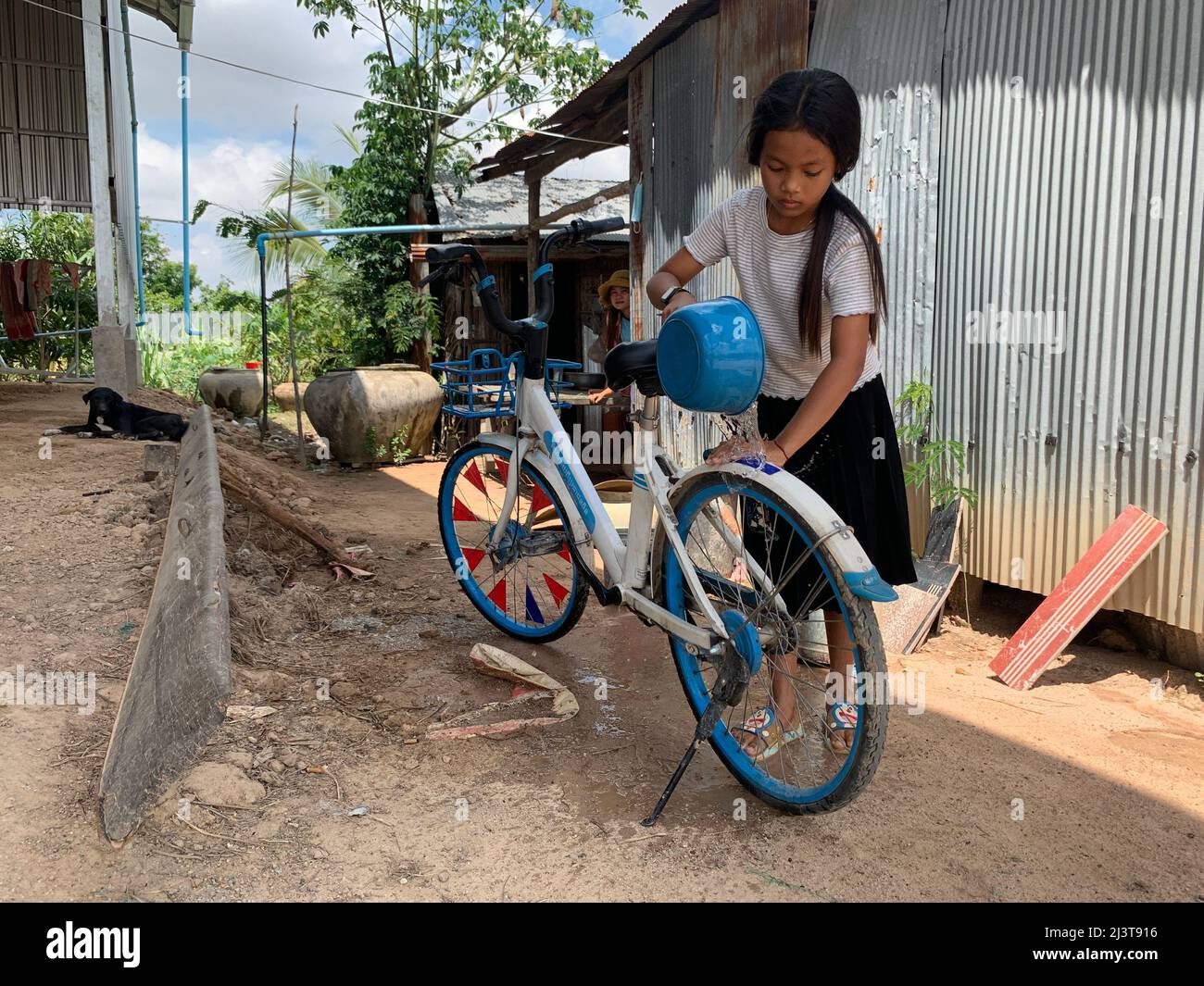 Takeo. 23rd mars 2022. Une étudiante de l'école primaire lave son vélo offert par Hello Inc. Dans la province de Takeo, au Cambodge, le 23 mars 2022. POUR ALLER AVEC "Feature: Les étudiants cambodgiens ruraux disent bonjour à des vélos chinois donnés" crédit: Van POV/Xinhua/Alamy Live News Banque D'Images