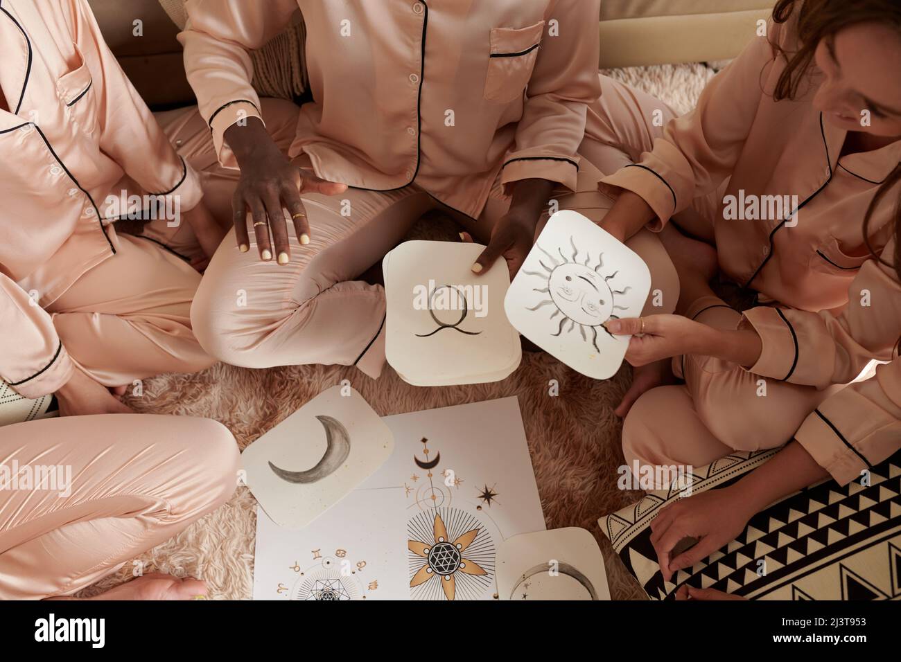 Femme expliquant comment l'astrologie de naissance fonctionne à ses amis à la fête de pyjama Banque D'Images