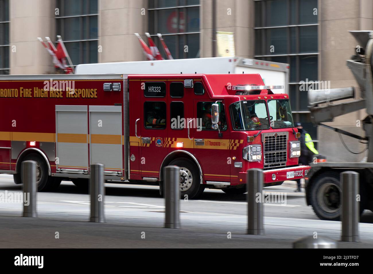 On voit un camion de pompiers de Toronto répondre à un appel, se précipitant dans la rue animée du centre-ville de Toronto. Banque D'Images