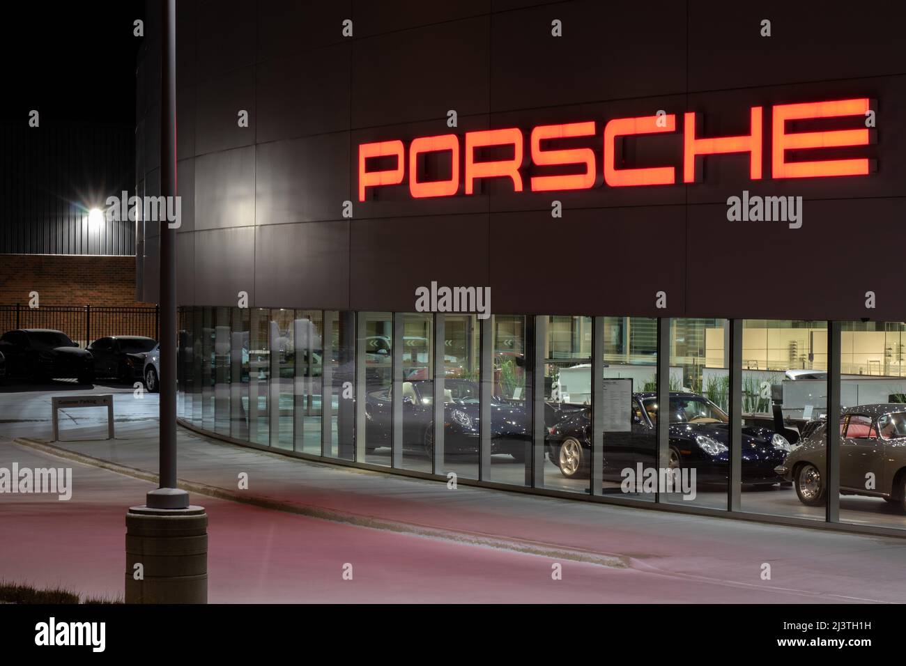 L'avant d'une Porsche, un constructeur automobile de luxe et de performance, concession la nuit. Banque D'Images